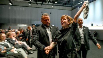 Aktivisten werden aus dem Saal gebracht bei der Vollversammlung der Volkswagen AG 2023