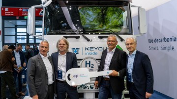 Jeweils zwei Geschäftsführer von Keyou und EP-Trans stehen vor einem Wasserstoff-Lkw.