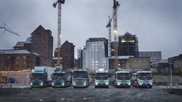 Volvo Trucks schwere E-Lkw Modelle stehen nebeneinander auf einer Baustelle