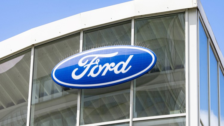 Logo von Ford an der Glasfassade eines Autohauses 