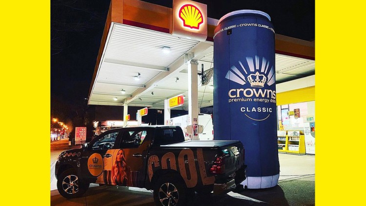 Eine aufblasbare Crowns-Premium-Dose vor einer Shell Tankstelle 